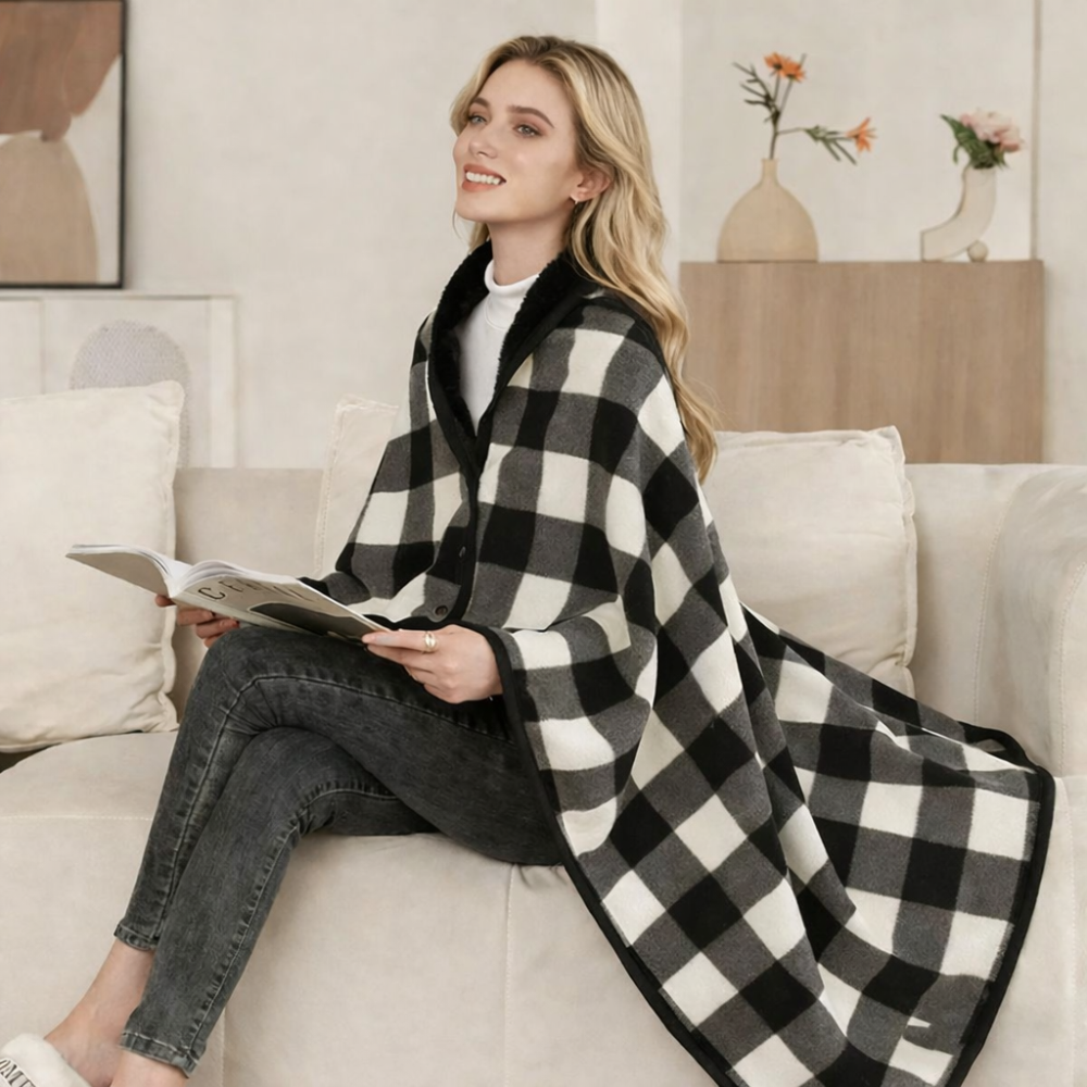 Woman wearing black and white plaid shawl while reading on a sofa
